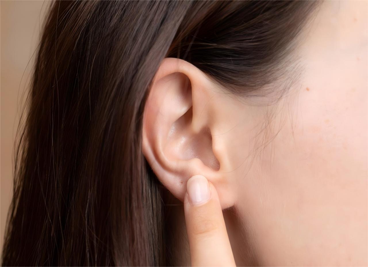 Finger pointing to ear.
